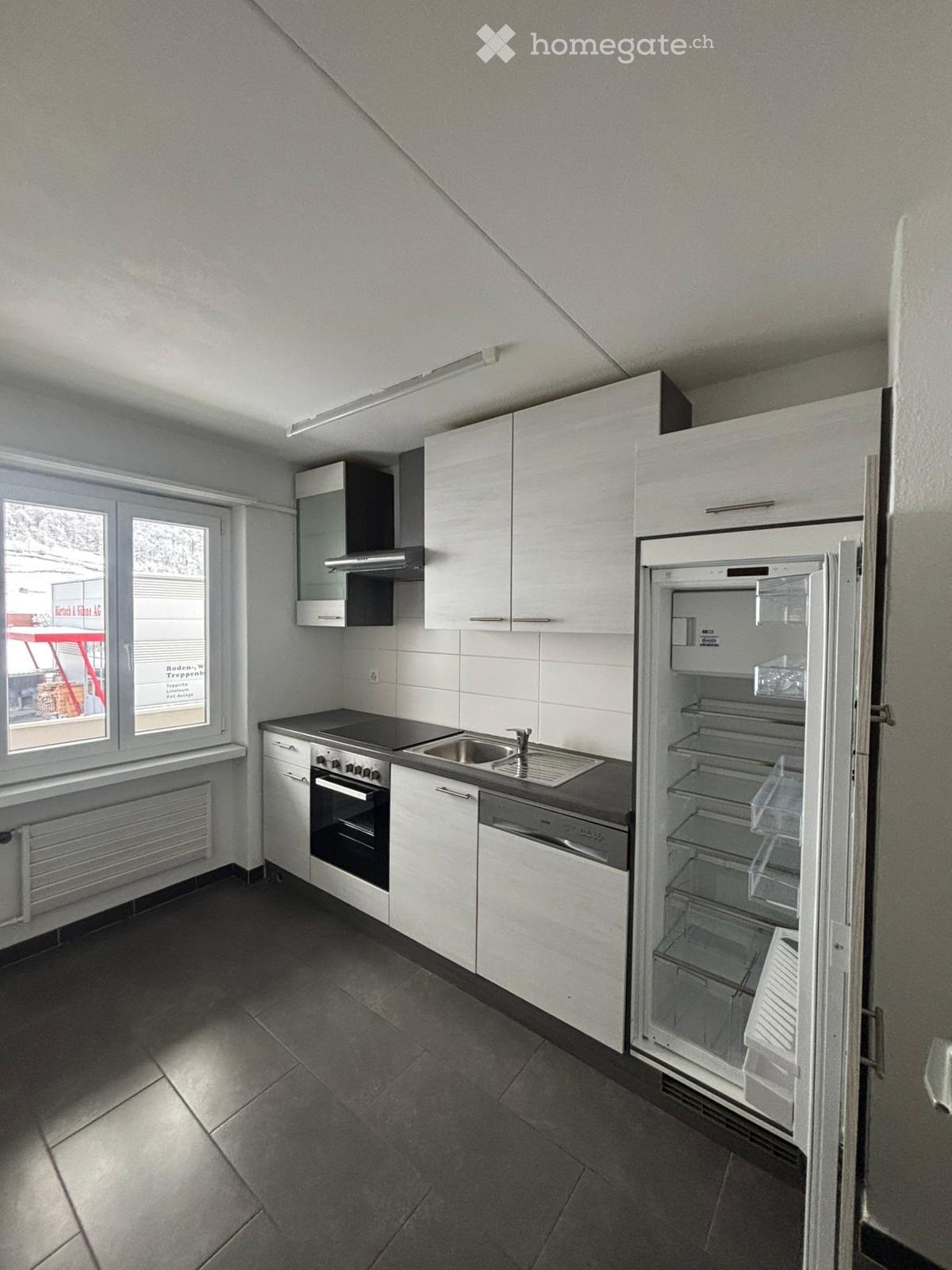 modern kitchen, white cabinetry, black countertop, stove, sink, dishwasher, refrigerator