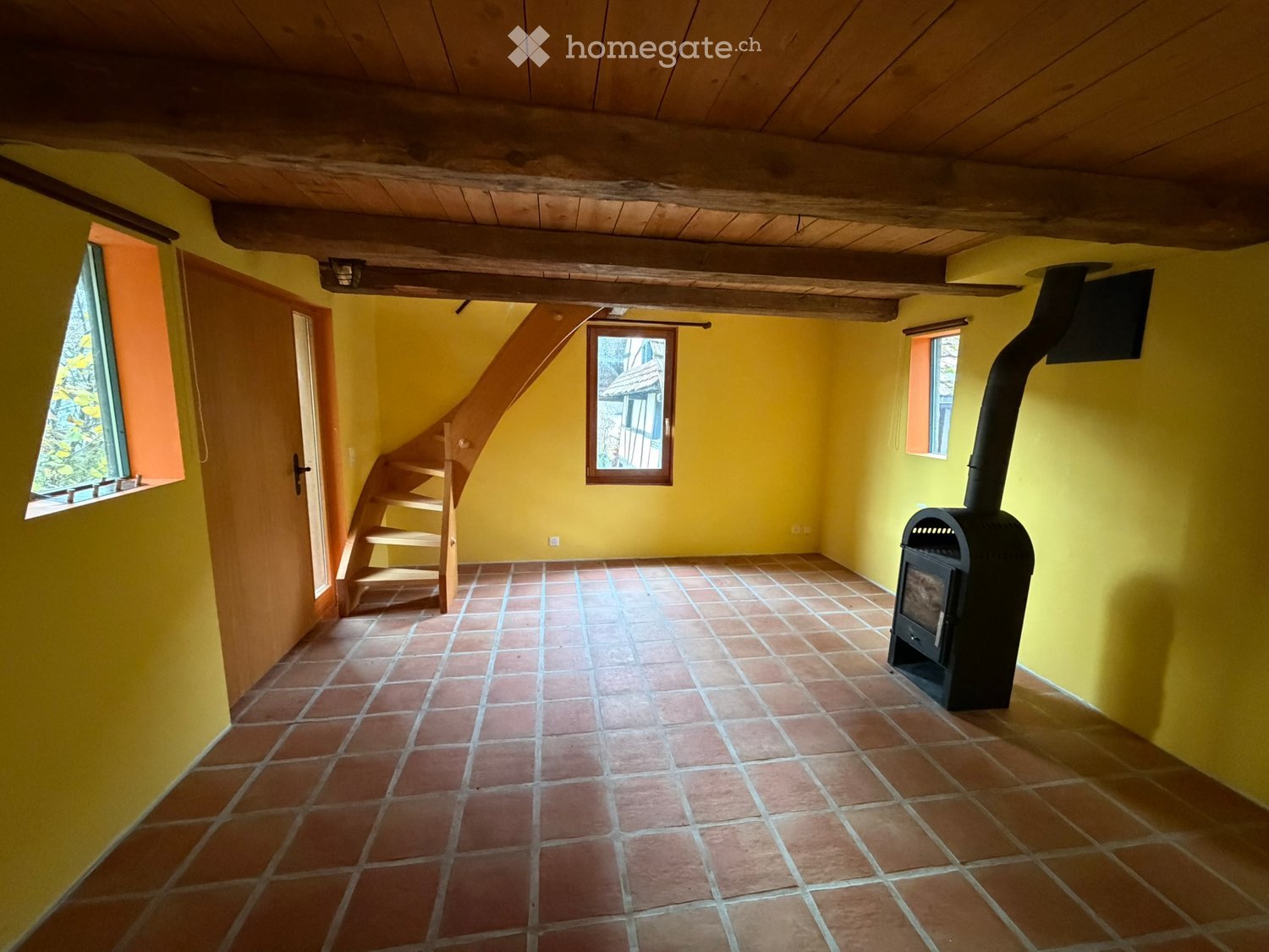 Fireplace, yellow walls, brick flooring, wooden staircase