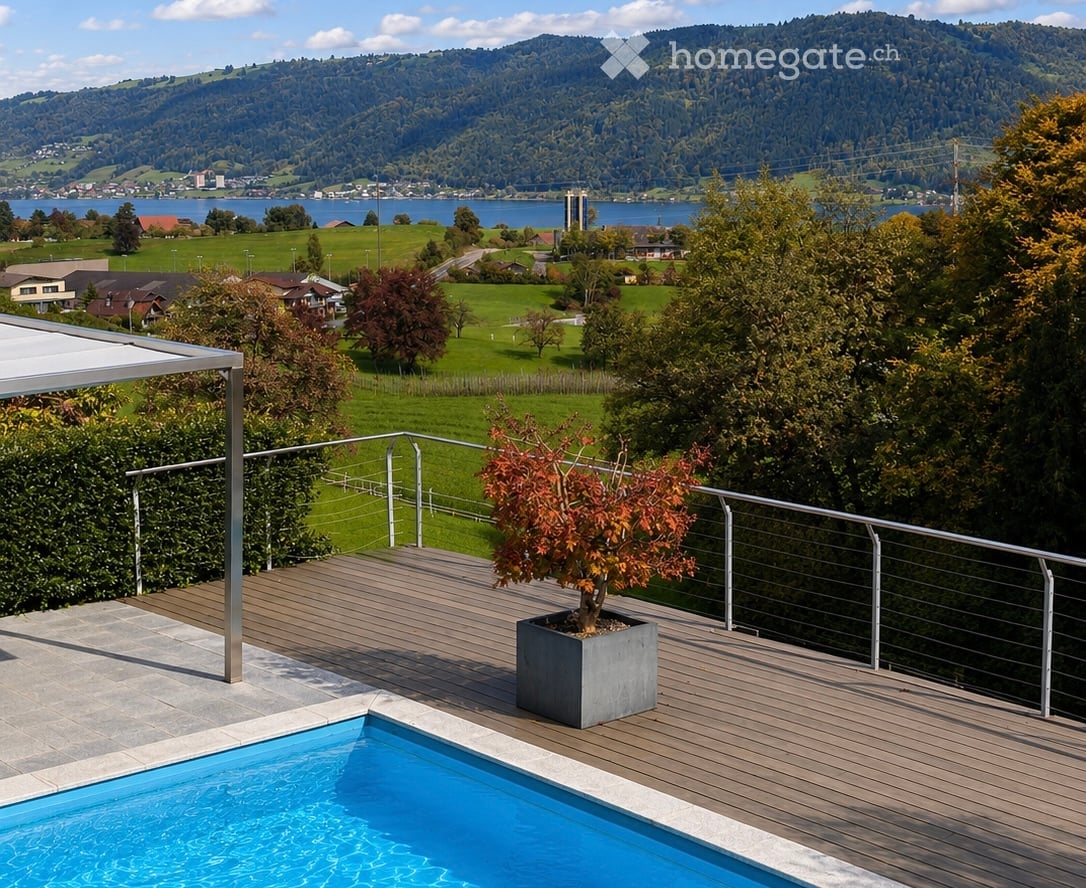 Outdoor terrace with a swimming pool, wooden decking, metal railing, and a potted plant, overlooking a scenic lake and mountain landscape.