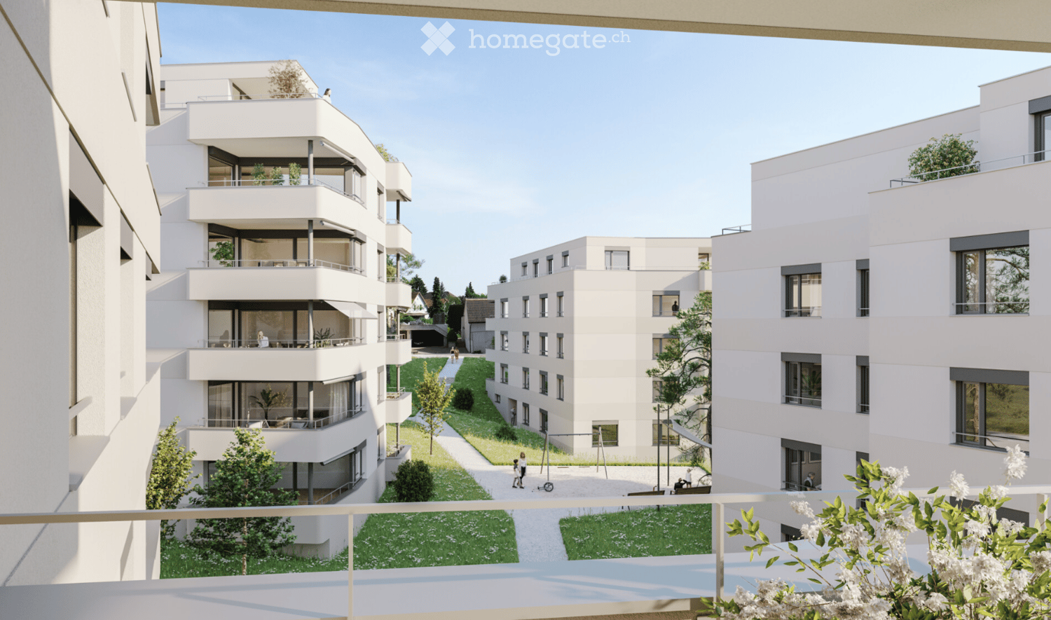 Modern residential complex with multiple white apartment buildings, balconies, greenery, and pathways.