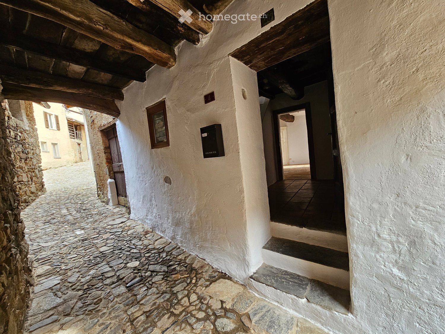 stone cobblestone street, whitewashed wall, entryway, wooden door, window