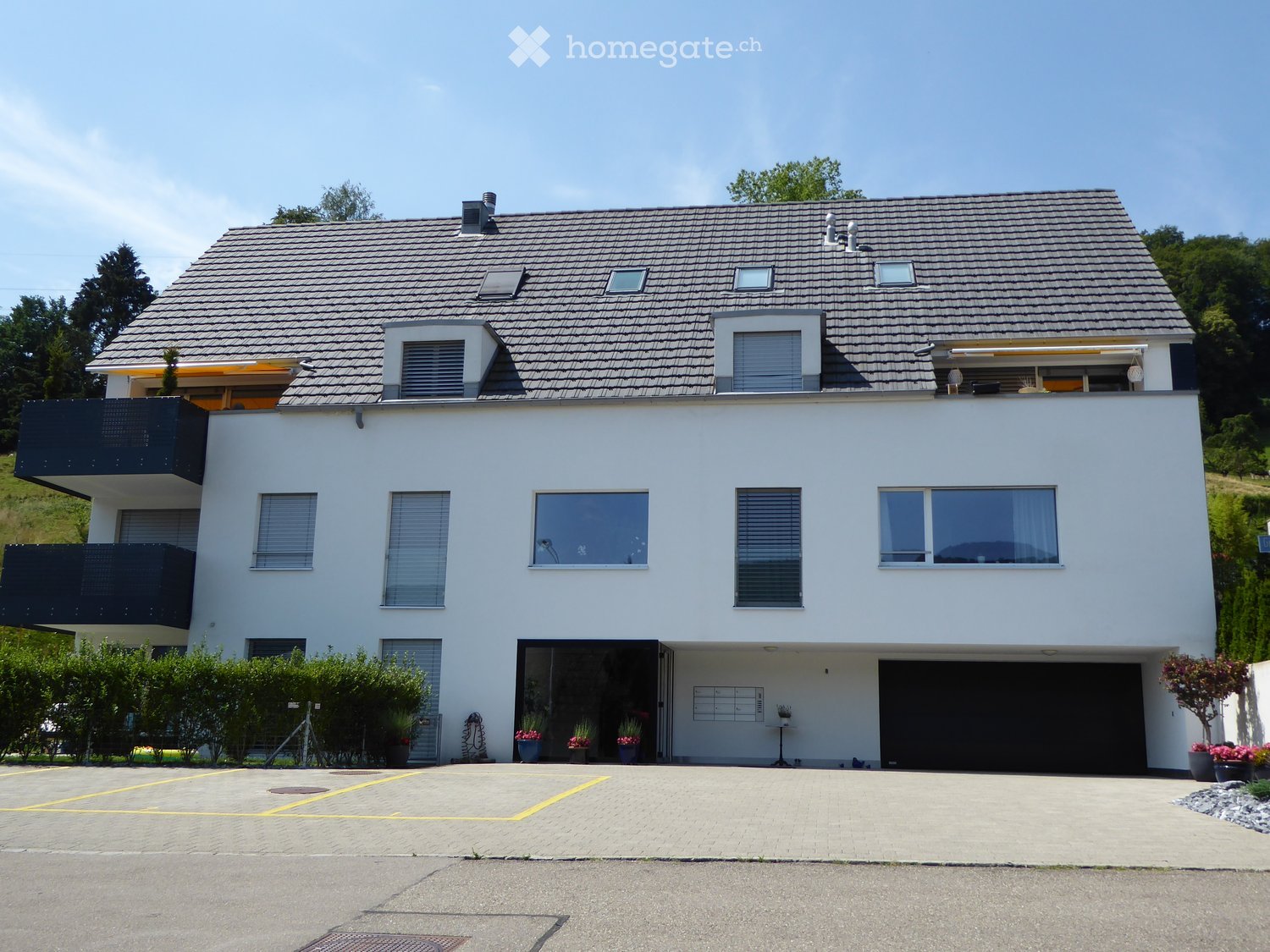 Two story house, white exterior, gray roof, garage, balconies