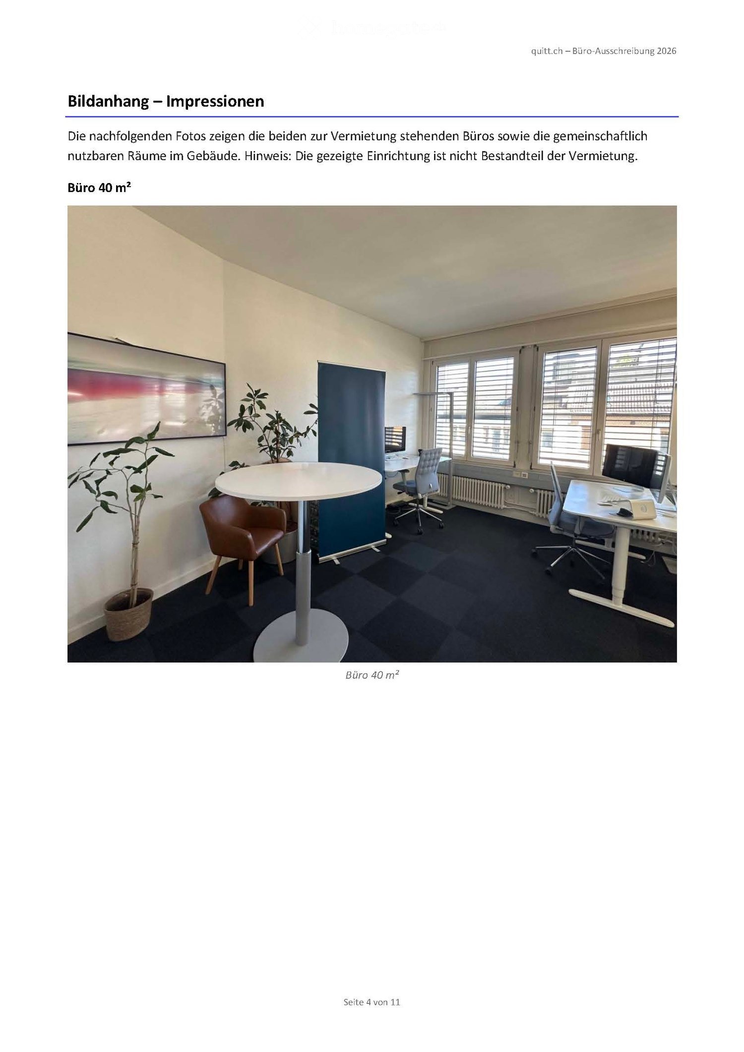 Office space with a round table, chairs, a plant, and a screen, large windows with blinds, and a dark blue partition.