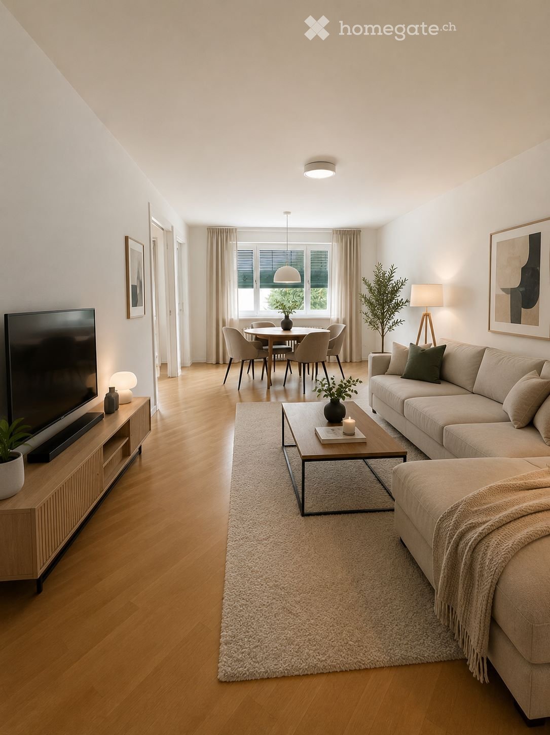 Modern living room with a beige sofa, coffee table, TV, dining area with chairs and table, and decorative plants.