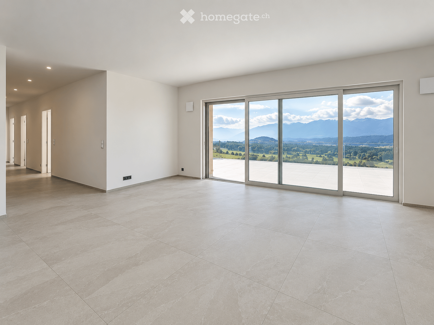 Empty room with large sliding glass doors leading to a balcony, tiled floor, and white walls.