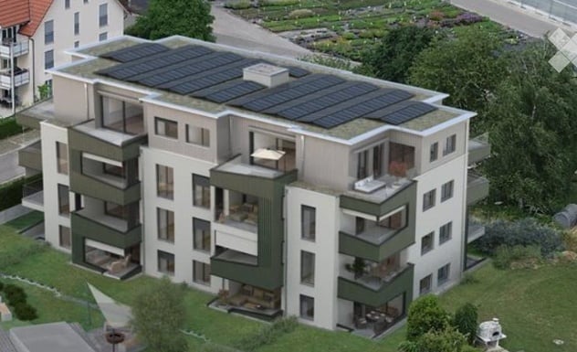 Multistory building, large solar panels on the roof, balconies, greenery in the area, multiple windows