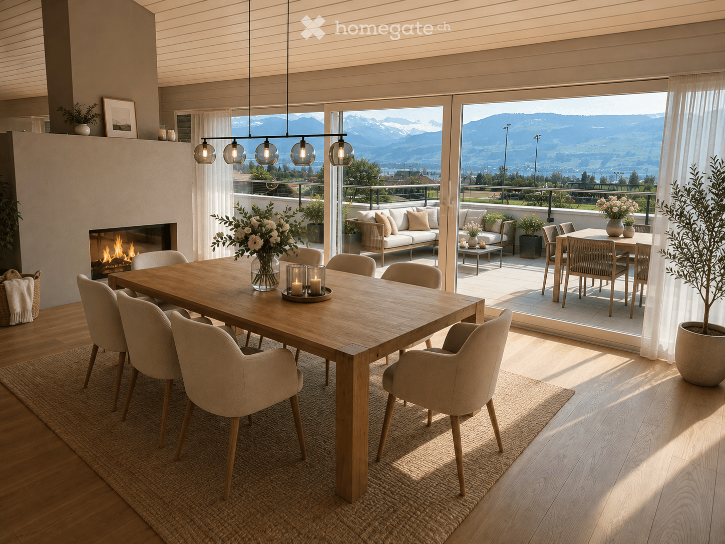 Modern dining room with a large wooden dining table, six chairs, a fireplace, a sofa, and a view of mountains through large windows.