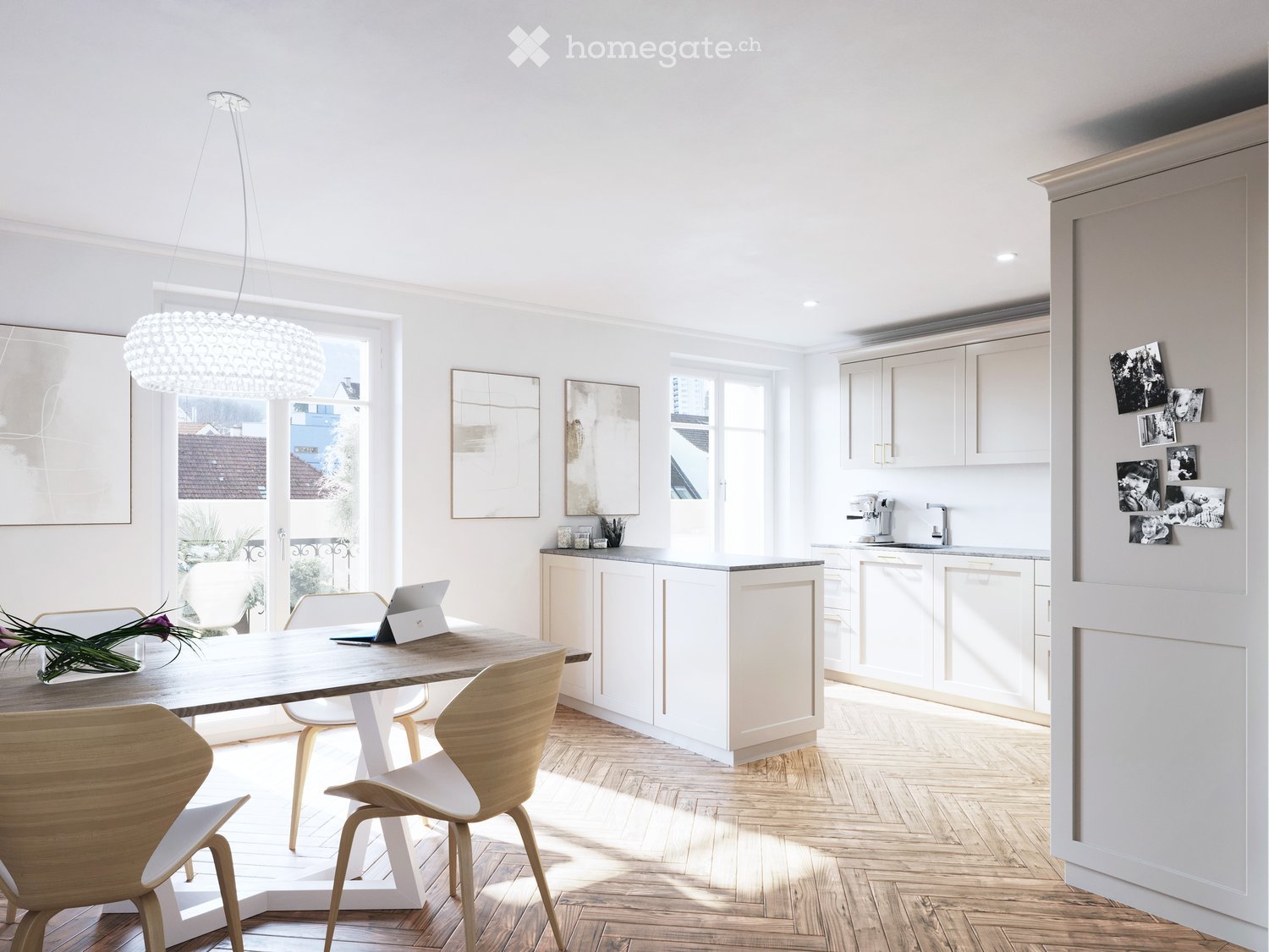 Bright, modern kitchen and dining area with white cabinets, wooden dining table, four chairs, laptop, coffee machine, and a large window with a view of the city.