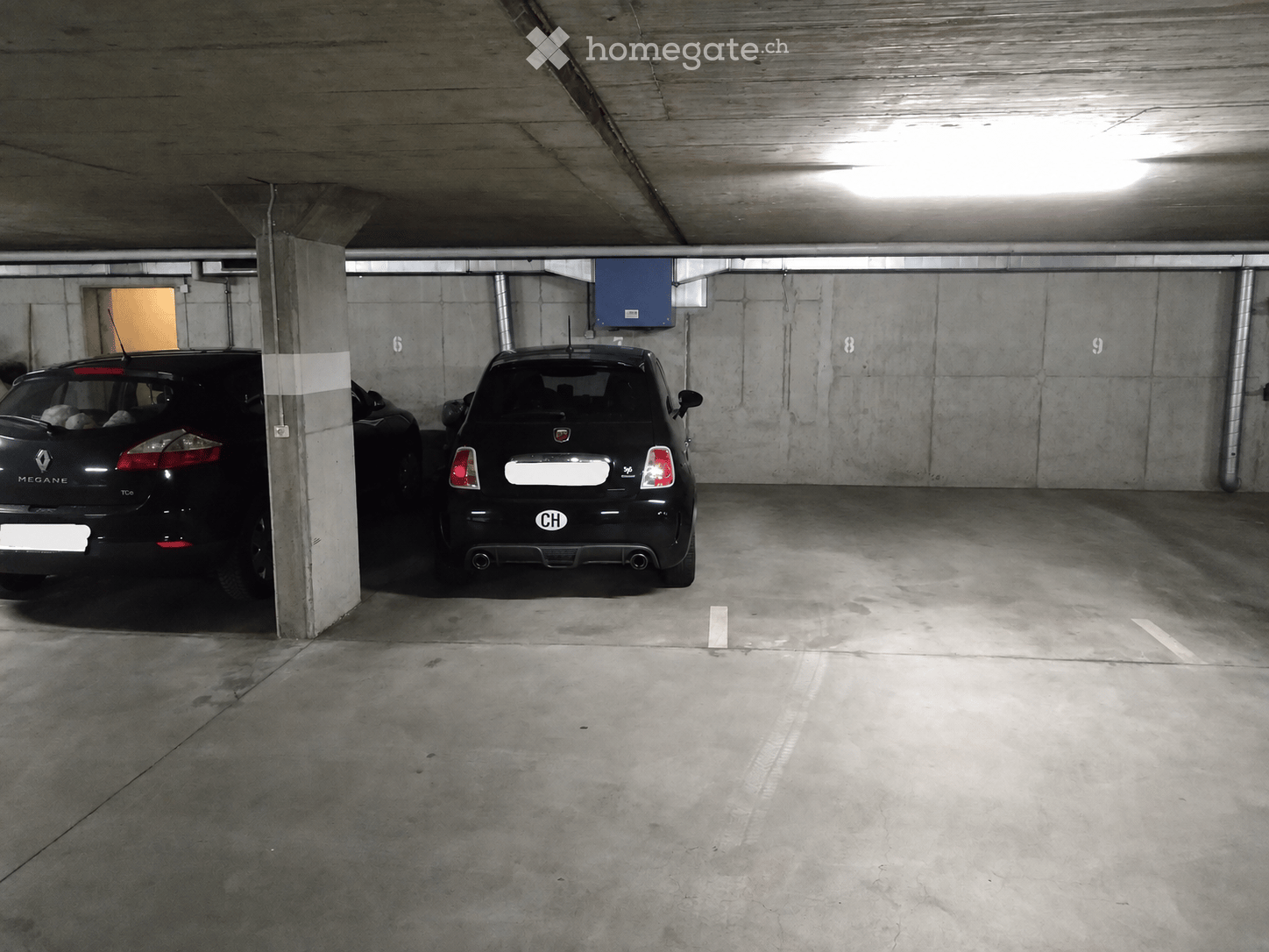 Underground parking area with two parked cars, concrete pillars, and numbered parking spots.
