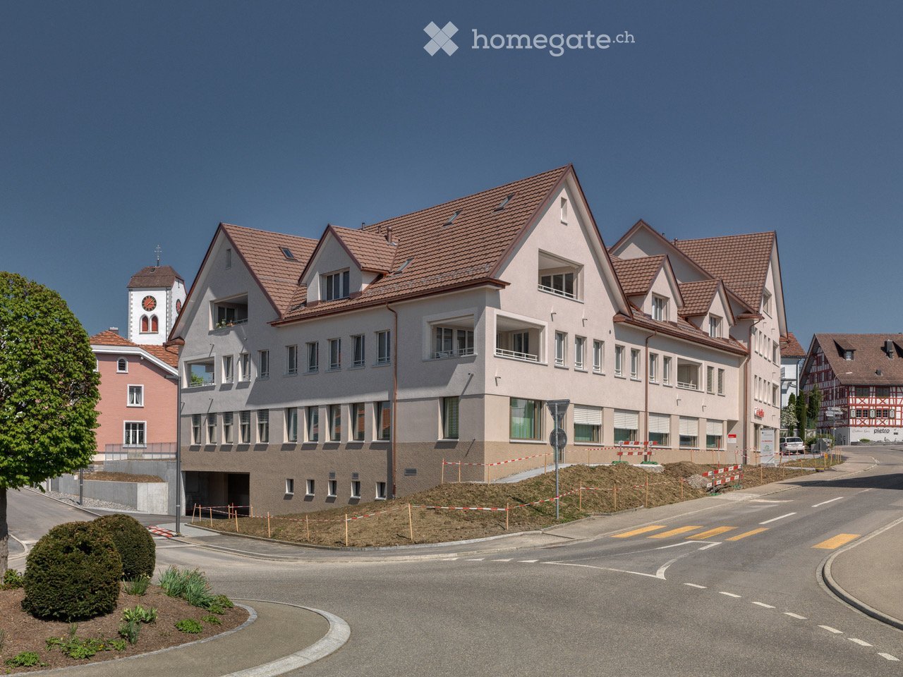Multi-family residential building, multi-storey, brown roof, multiple windows, garage