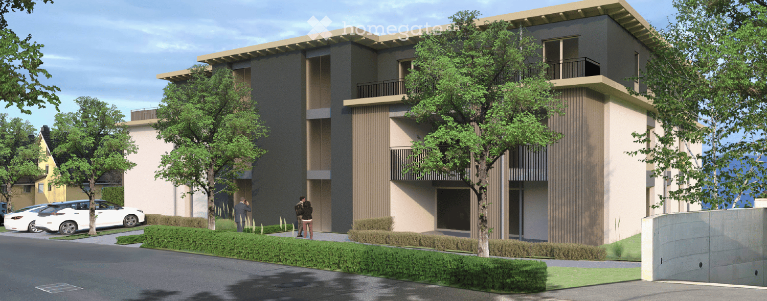 Modern two-story residential building with balconies, surrounded by trees and parked cars.