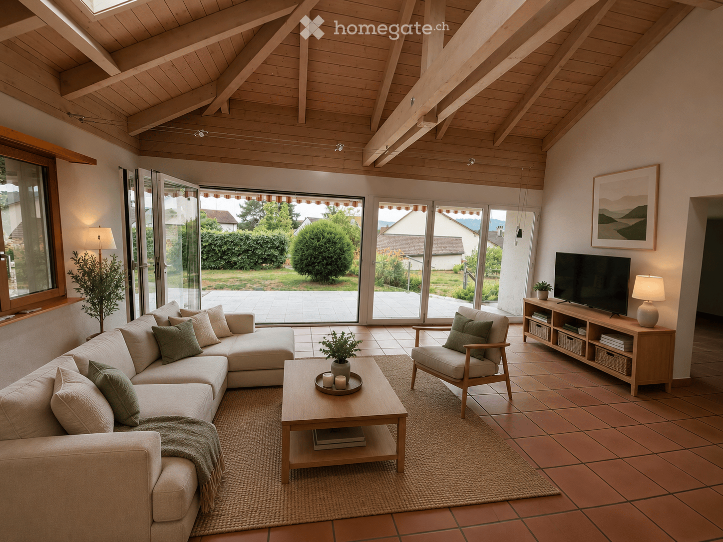 Bright living room with exposed wooden beams, large sliding glass doors leading to a garden, a beige sectional sofa, a wooden coffee table, an armchair, a TV on a wooden stand, and table lamps.