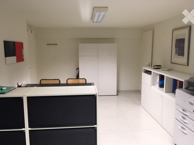 Office space with white tiled flooring, white walls, and modern furniture including a desk, chairs, cabinets, and a printer.