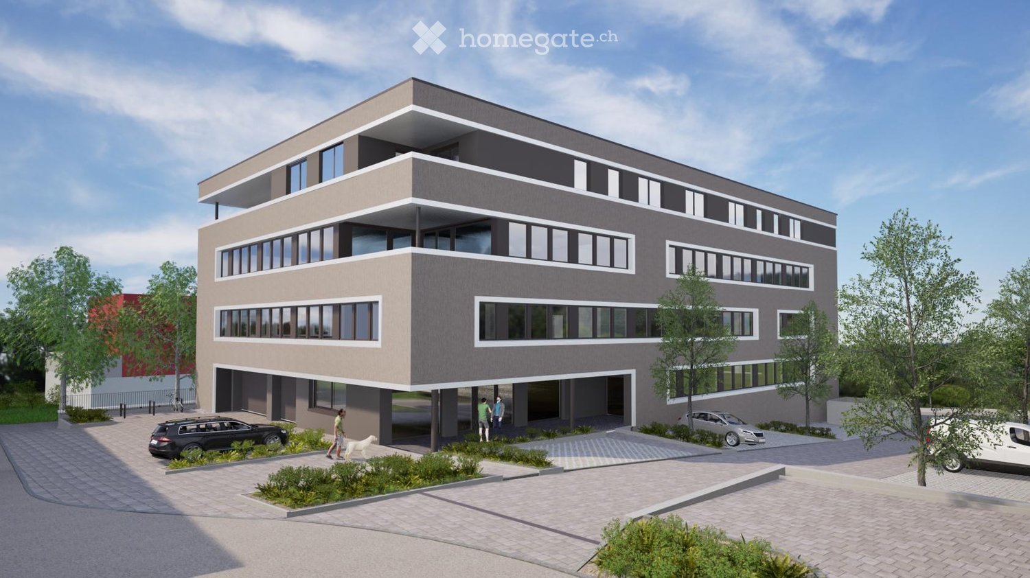 Modern multi-story building with a contemporary design, featuring large windows, a raised ground floor, and a parking area with several cars.