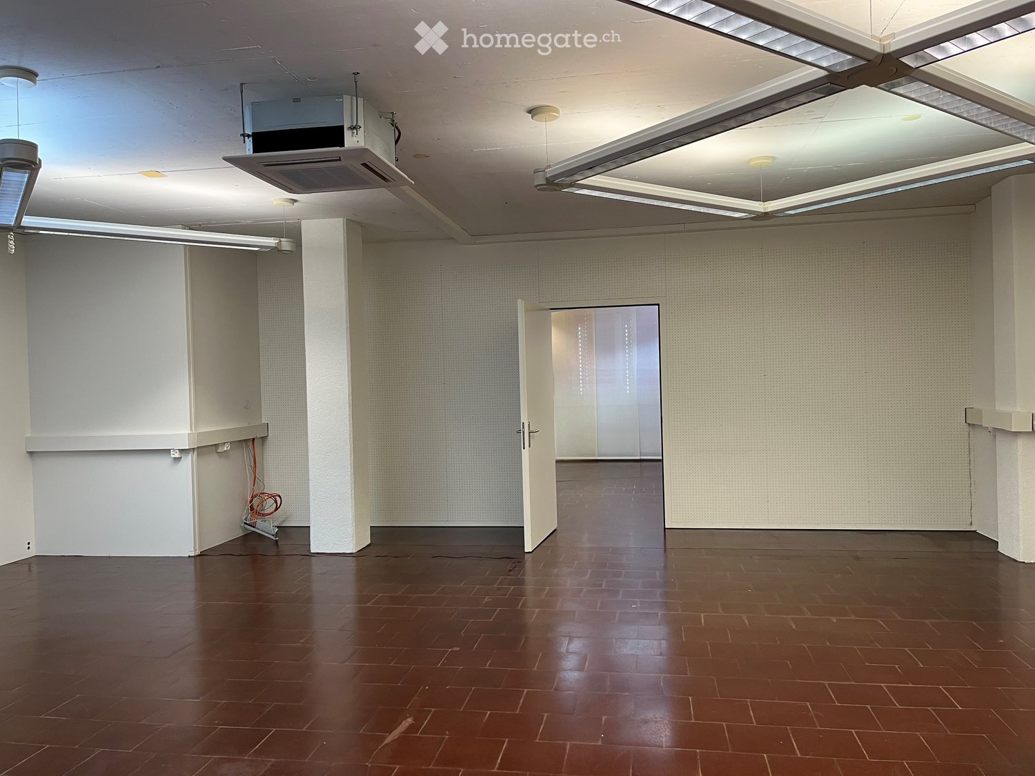empty room, white walls, brown tiled floor, open door, ceiling lights