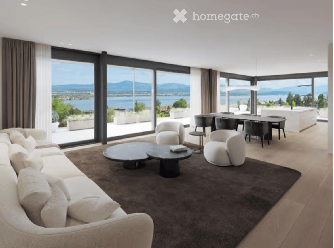 Modern living room with large windows offering a scenic view, featuring a white sectional sofa, coffee table, armchairs, and a dining area with a table and chairs.