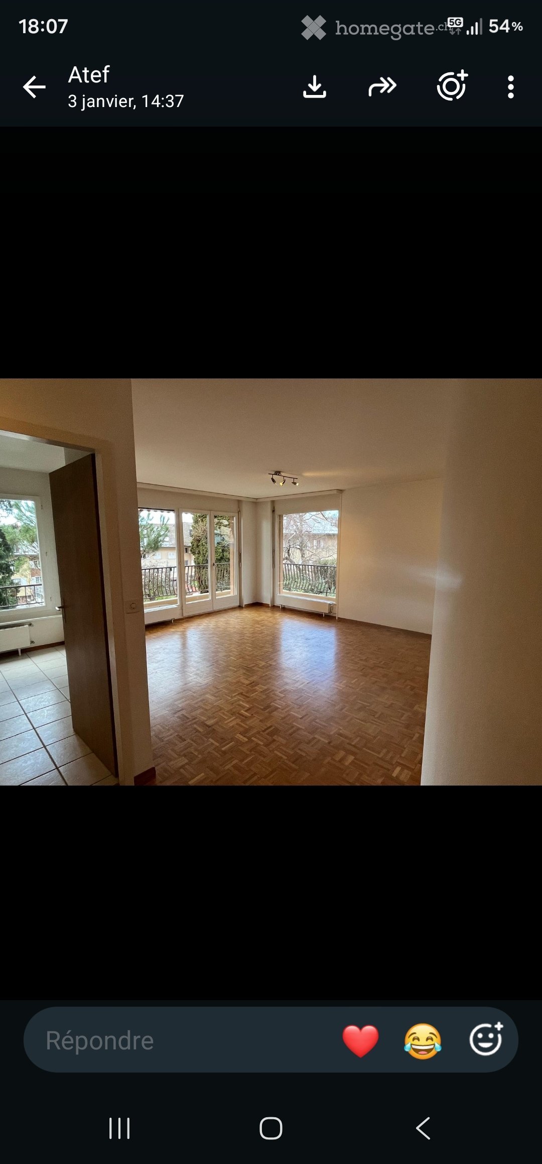 Empty room with wooden flooring, large windows, and access to a balcony.