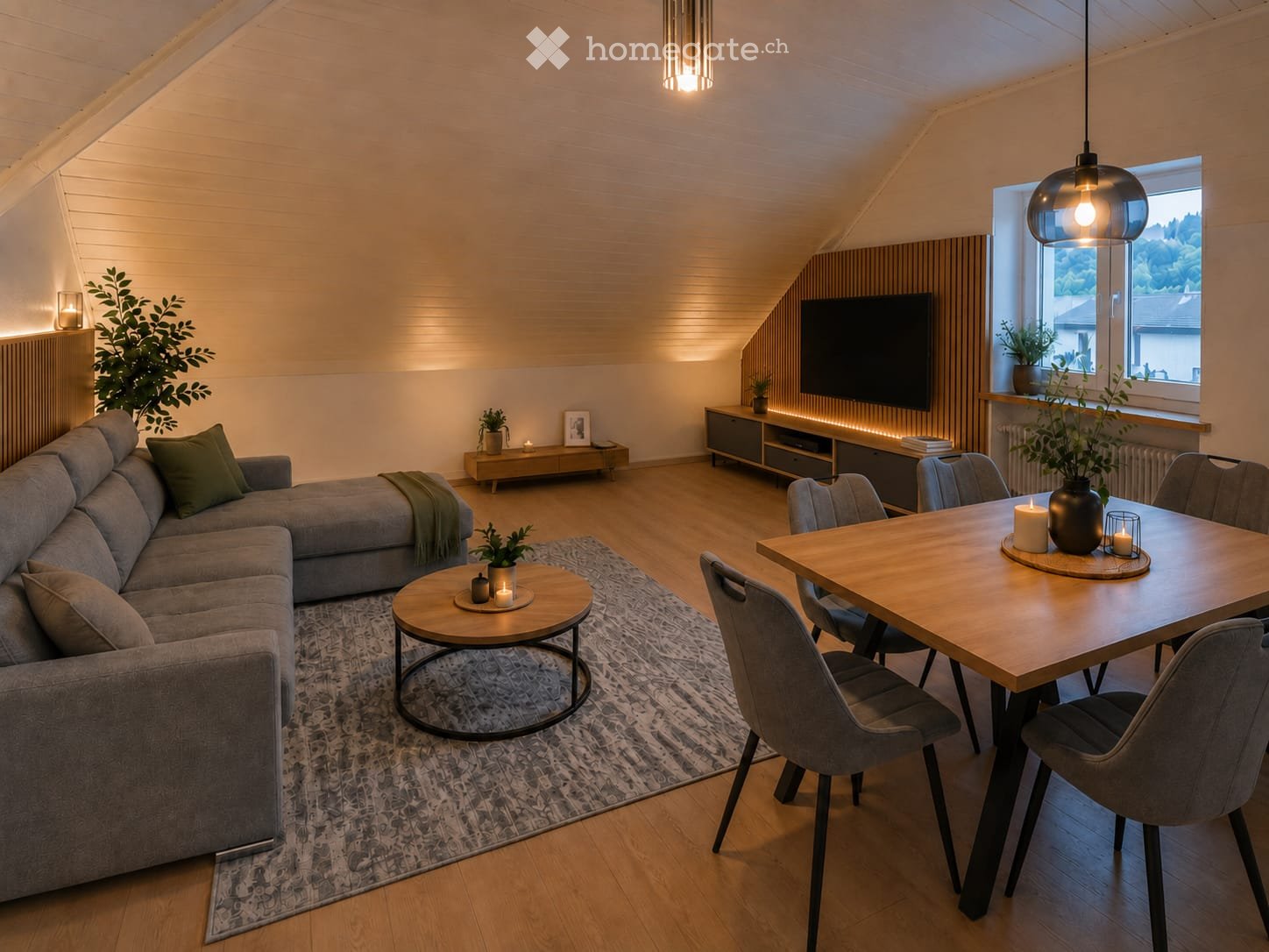 Modern living and dining area with a grey sectional sofa, coffee table, dining table with chairs, TV, sideboard, and decorative plants.