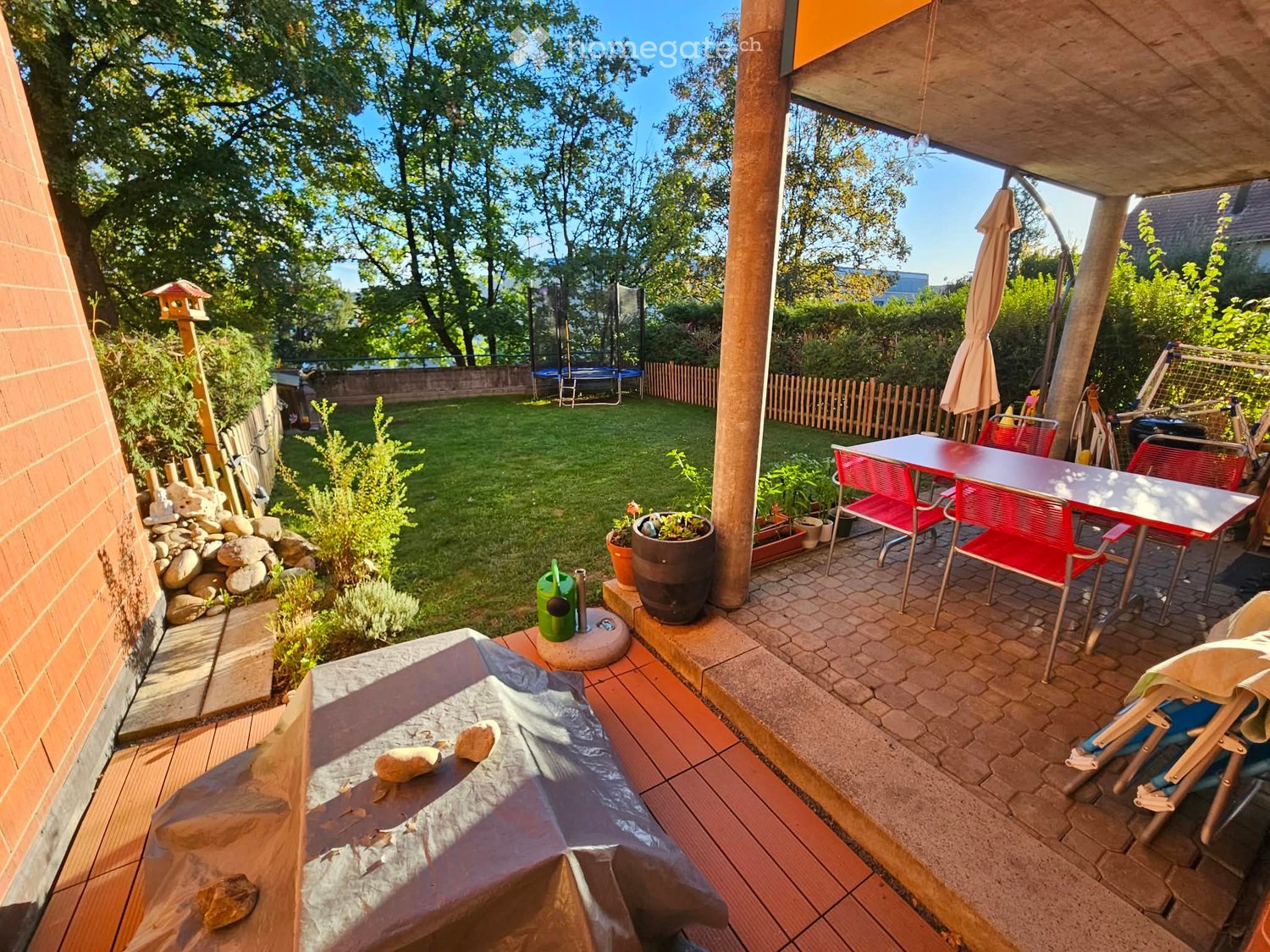 Garden area with a patio, outdoor furniture, potted plants, and a covered seating area.