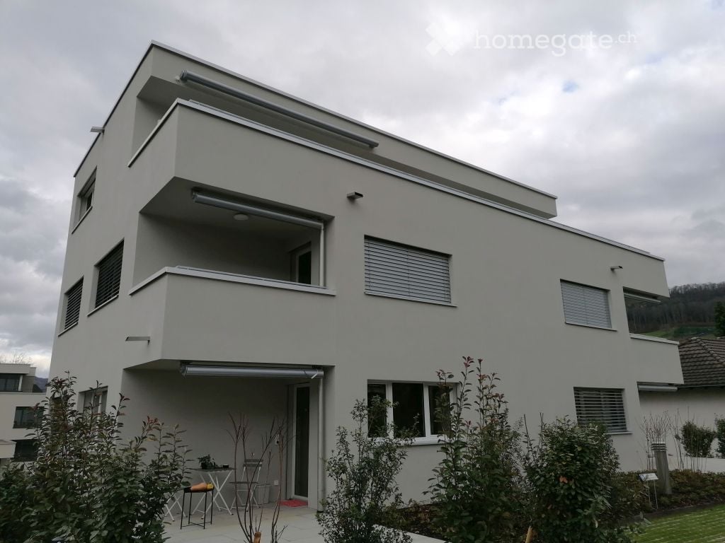 2 story house, white paint, large windows, balcony, table and chairs