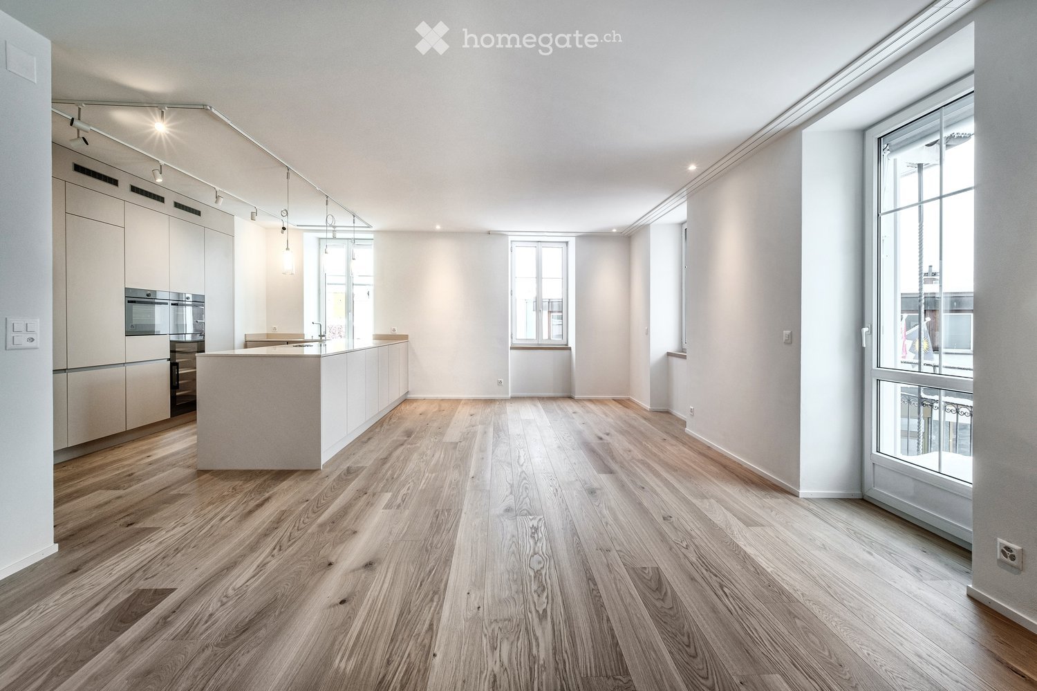 modern kitchen with island, wooden floors, white walls, large windows, modern appliances