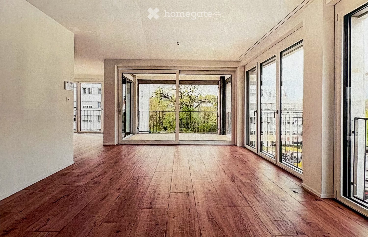 Empty room with wooden flooring, large windows, and sliding glass doors leading to a balcony area.