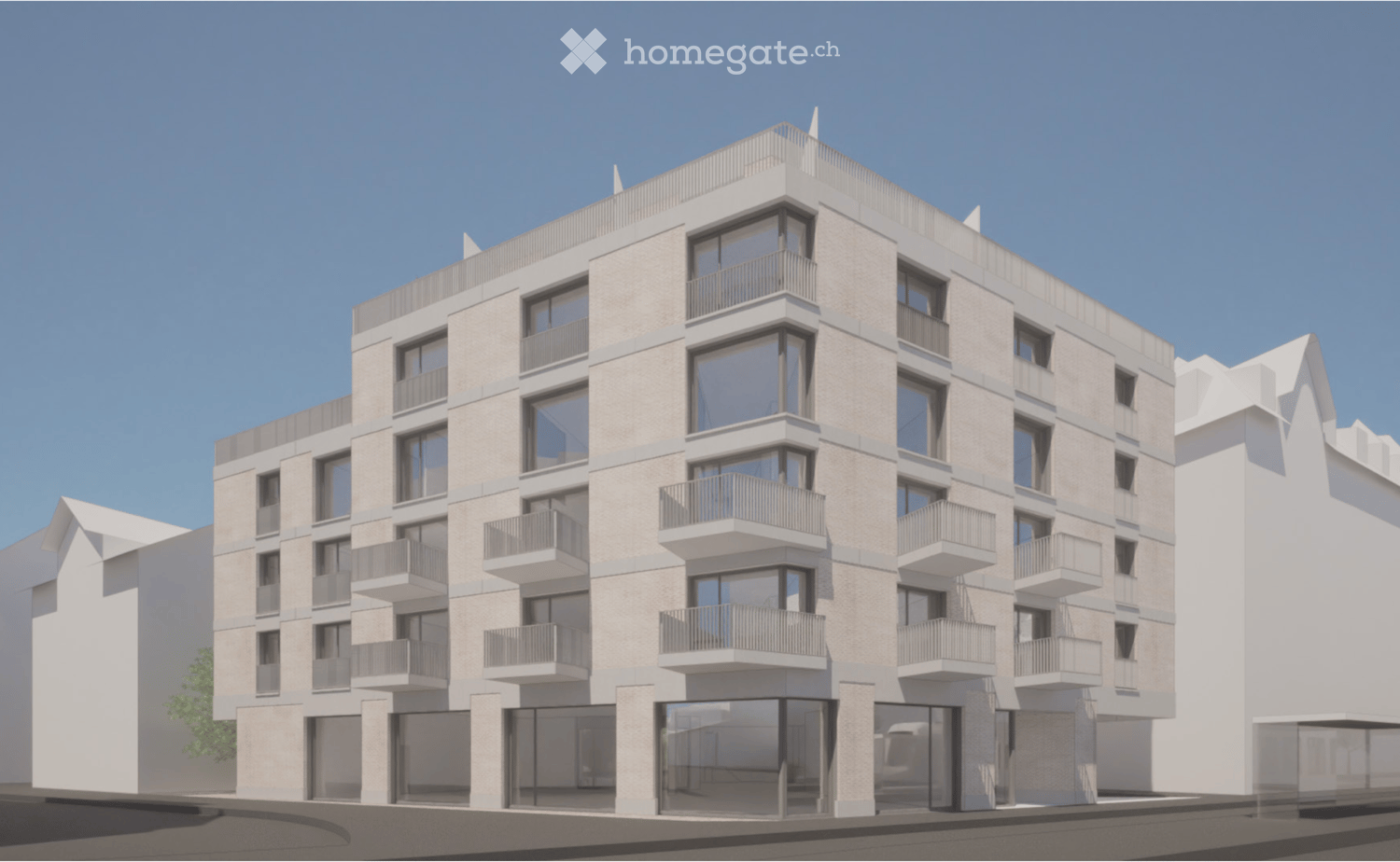 Modern multi-story building with glass windows and balconies. The building has a white exterior with a brick pattern on the facade. It features a flat roof with a small balcony on top. The ground floor has large glass doors and windows, likely for commerc