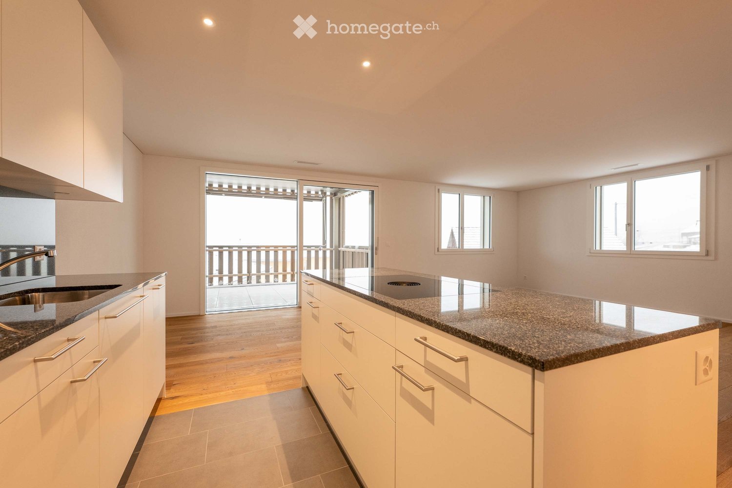 modern kitchen with granite countertop, white cabinets, sink, faucet, sliding glass door to balcony, wooden floor