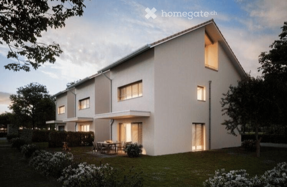 Modern two-story house with white exterior, large windows, and a small outdoor seating area with a table and chairs.