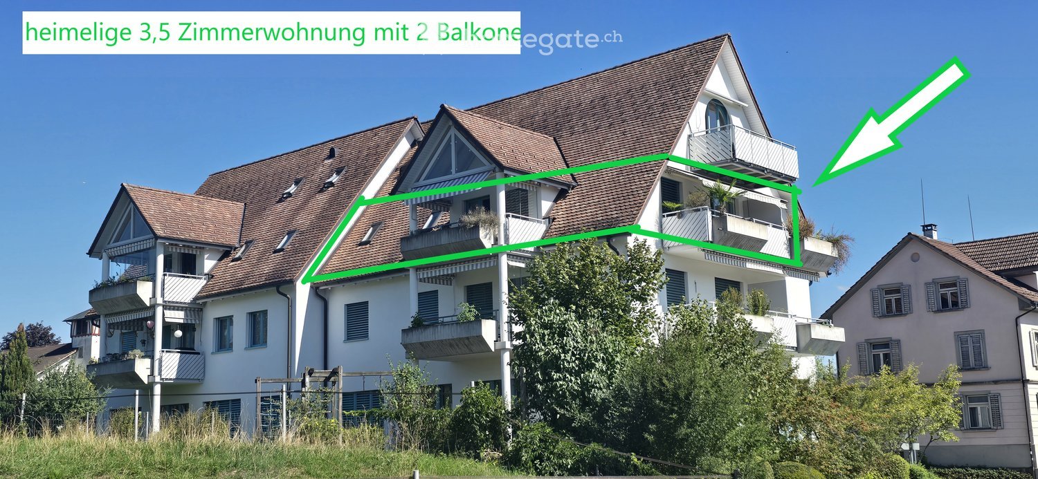 Multi-story residential building with brown tiled roof, white exterior, multiple balconies, and greenery in front.