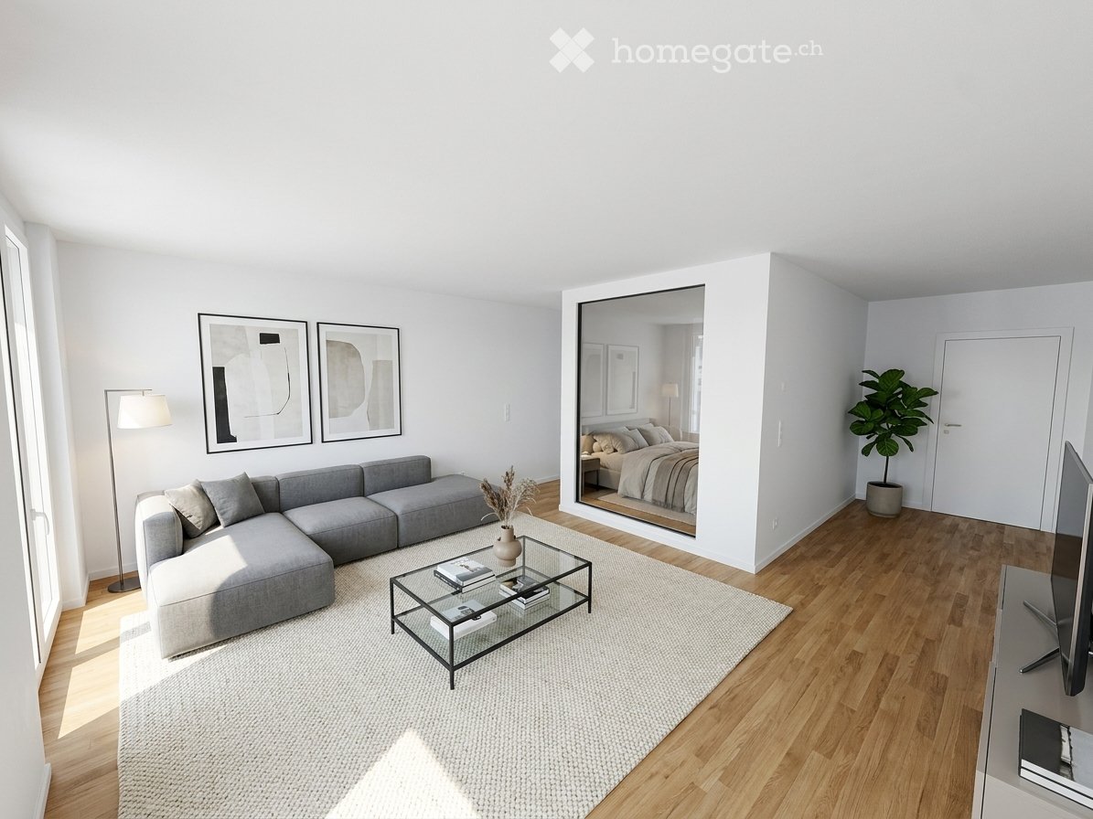 Modern living room with grey sectional sofa, glass coffee table, floor lamp, large mirror, potted plant, and TV stand.