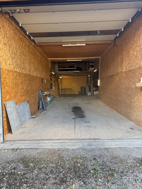 {"visible_features": ["Garage"], "type": "Garage", "objects": [], "description": "Open garage with wooden walls, concrete floor, and some storage items in the background.", "localized_descriptions": {"EN": "Open garage with wooden walls, concrete floor, a