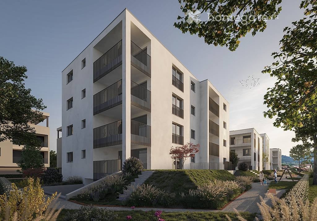 Modern multi-story residential building with white facade, balconies, and surrounding greenery.
