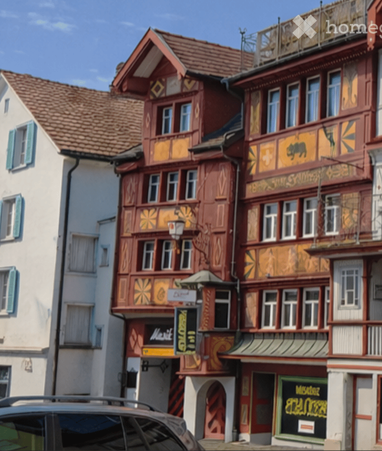 A row of traditional half-timbered houses with colorful facades, decorative carvings, and multiple stories, featuring shops and signage at the ground level.