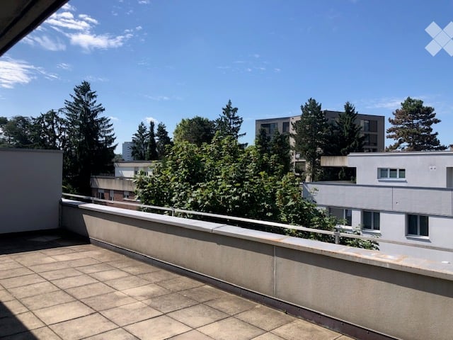 Outdoor terrace, tiled flooring, metal railing, view of nearby buildings and trees
