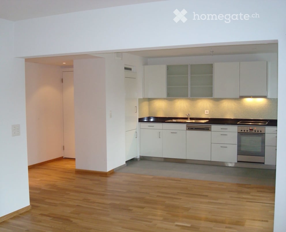 Empty modern kitchen with a sink, faucet, dishwasher, and oven.