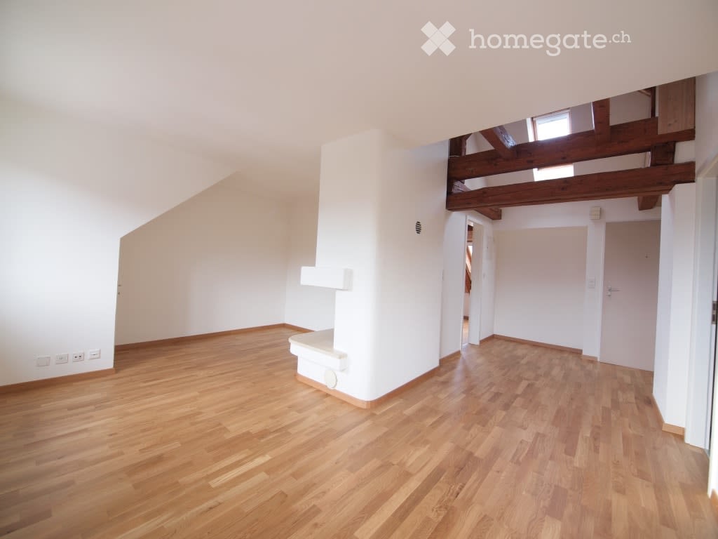 Empty room with wooden flooring, white walls, and exposed wooden beams on the ceiling. No furniture or equipment present.