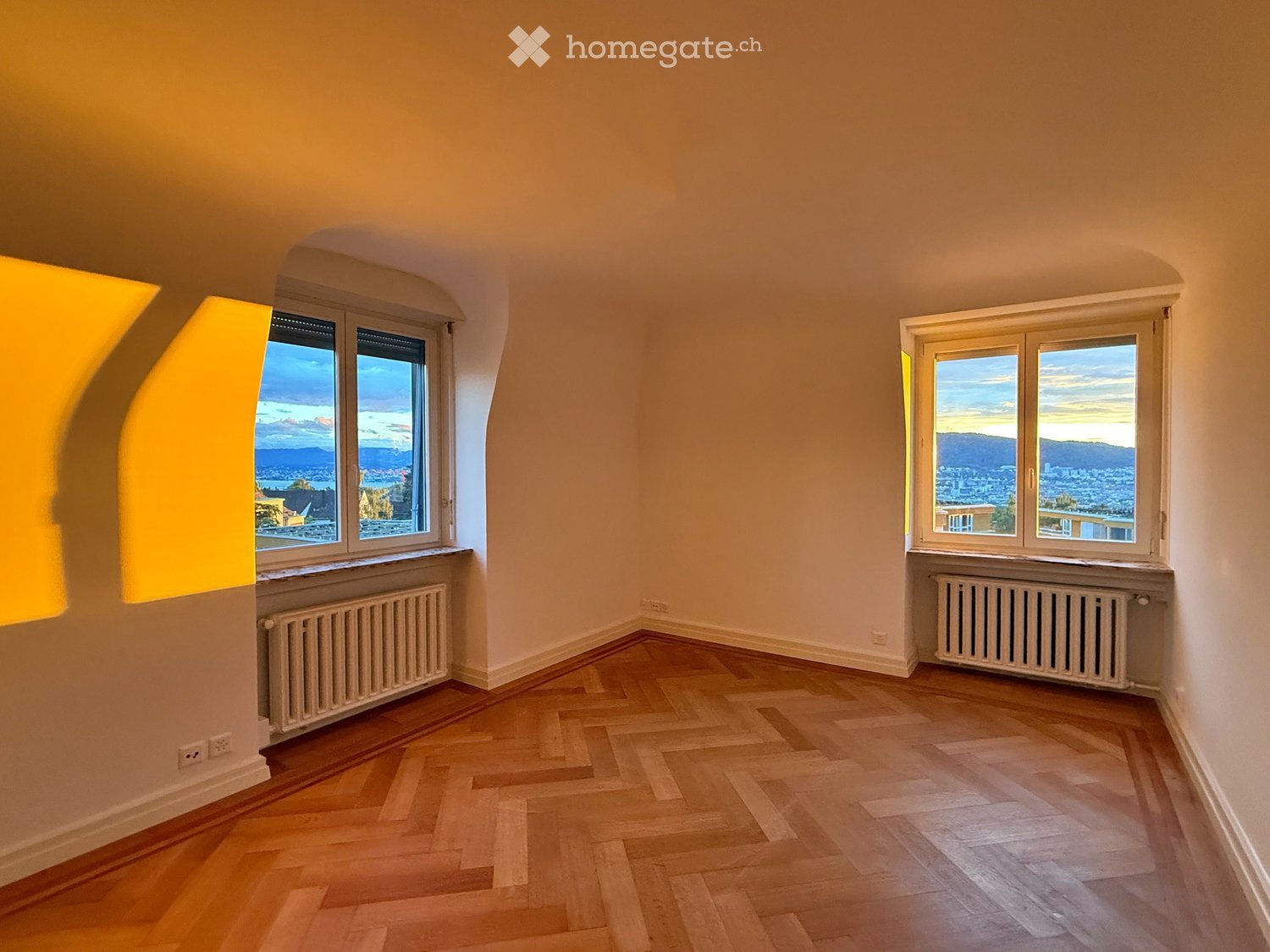 empty room, white walls, wooden floor, windows with city view, white radiators