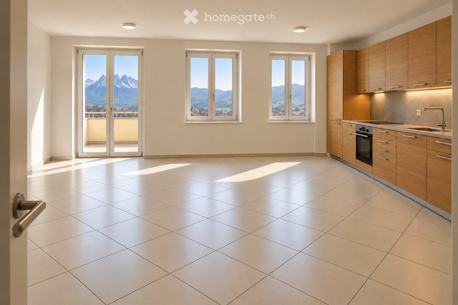 Modern kitchen with light wooden cabinets, stainless steel sink, and oven. Large windows offer a scenic mountain view, and the space is well-lit with natural light.