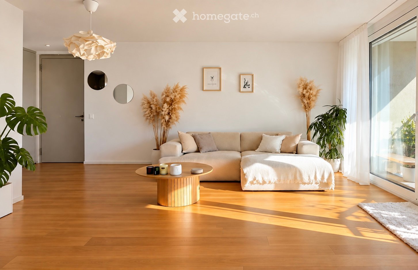 Modern living room with light-colored sofa, wooden coffee table, floor lamp, and large windows letting in natural light.