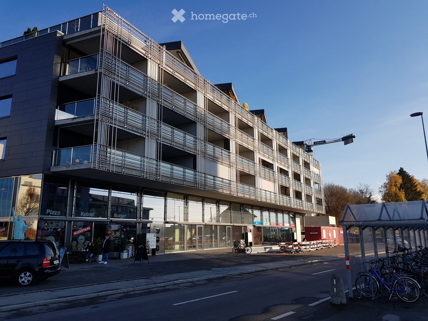 A multi-story residential building with glass facades, multiple balconies, and modern architectural design