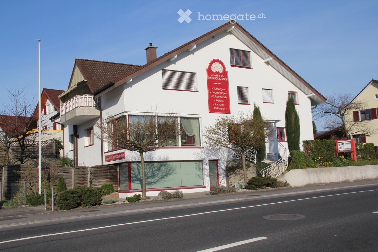 white house, brown roof, balcony, red sign, glass windows, stairs, garden, street