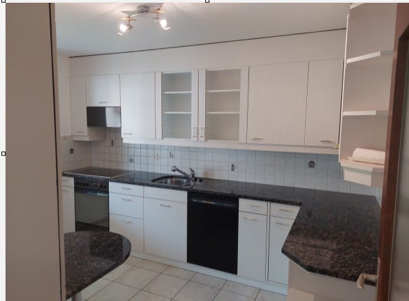 Modern kitchen with white cabinets, granite countertops, and stainless steel appliances including a sink, oven, and dishwasher.