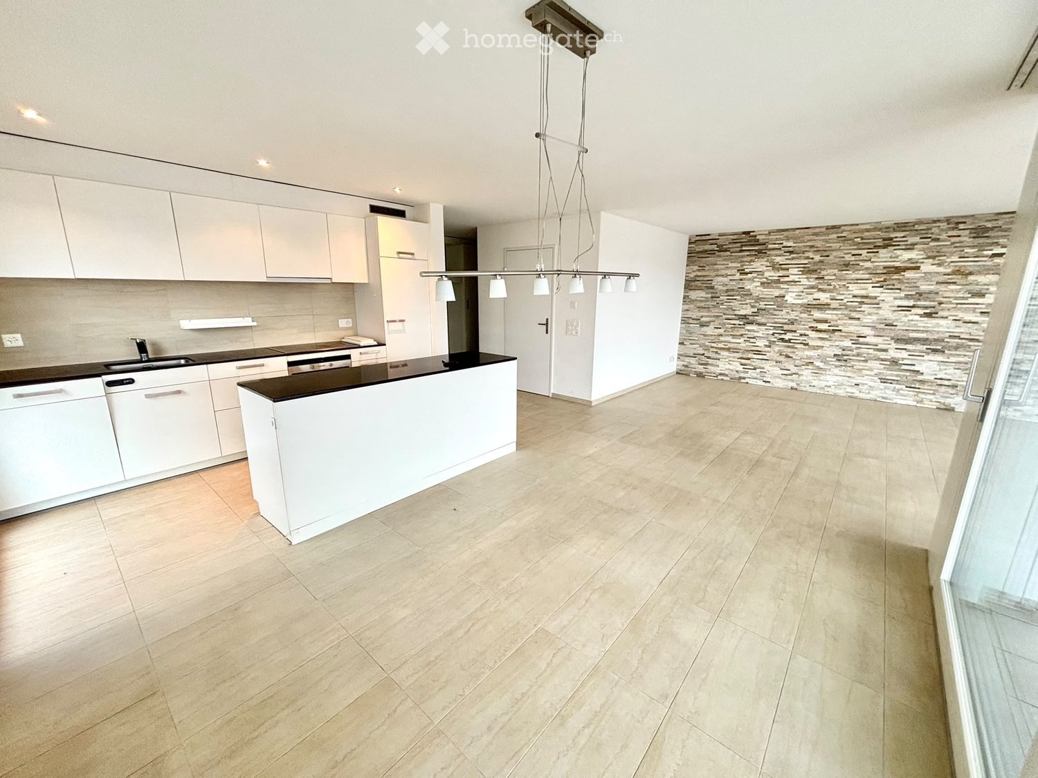 Modern kitchen with white cabinets, a central island, and a sleek black countertop. Features include a built-in sink, faucet, and a dishwasher.