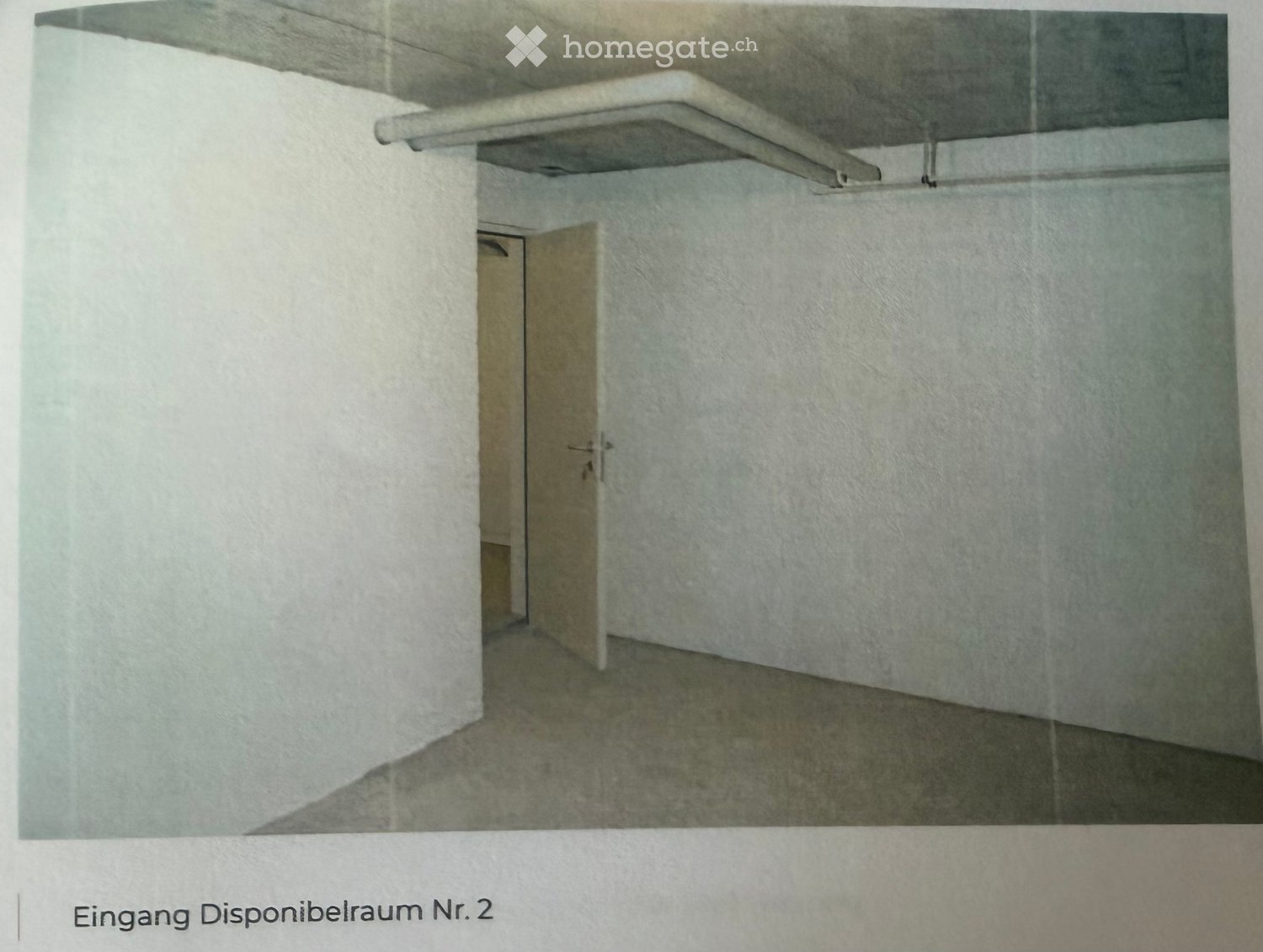 Empty room with white walls, concrete floor, and a single open door leading to another space.