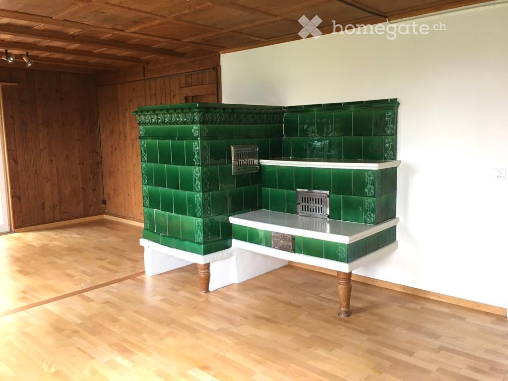 Empty room, wooden floors, wooden walls, white wall, green tiled fireplace, white table top