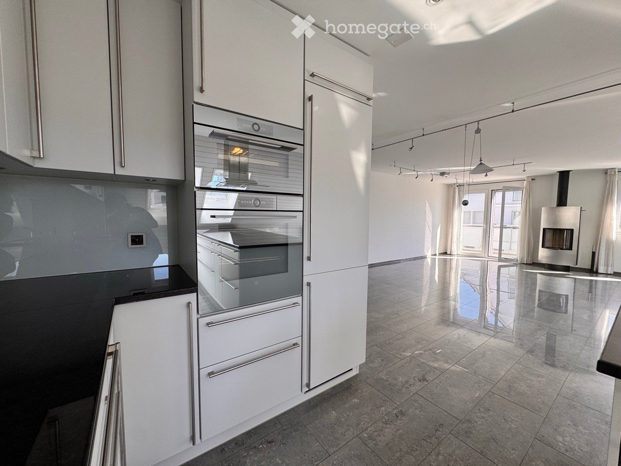 Modern kitchen with white cabinets, stainless steel appliances, and a central island.