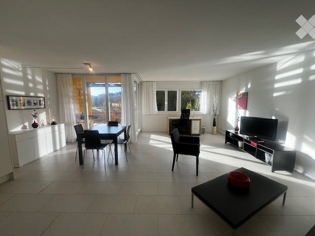 open plan living room, dining area, large windows with curtains, TV stand, black coffee table, black dining table, white cabinets, black chairs