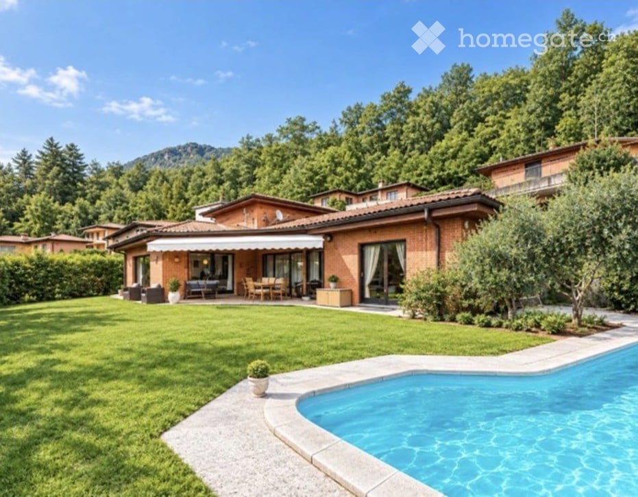 Villa with a swimming pool, well-maintained lawn, outdoor seating area, and scenic mountain view.
