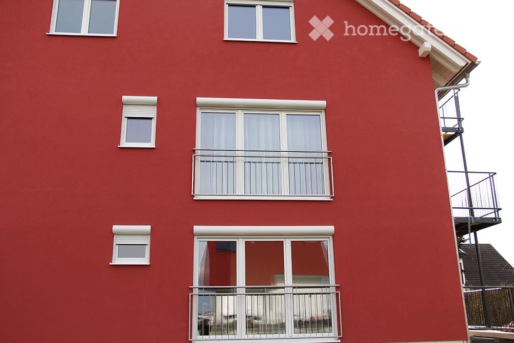Red brick building with multiple windows and balconies.